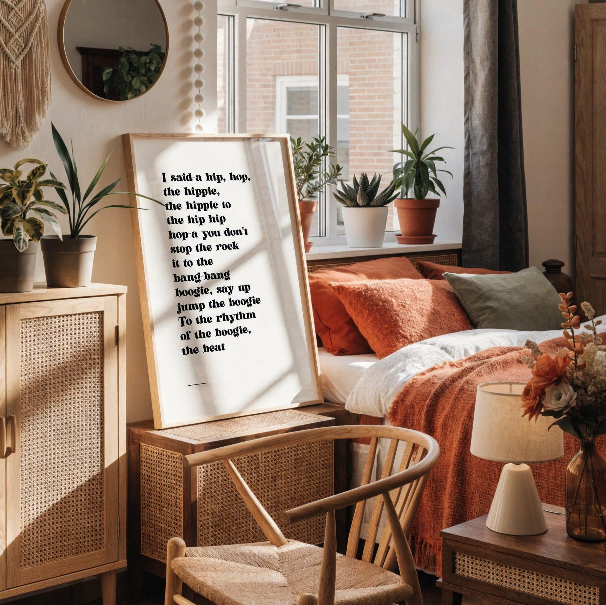 a framed quote on a white wall, accompanied by a white desk with various items such as a coffee cup, a notebook, and a vase with dried flowers.