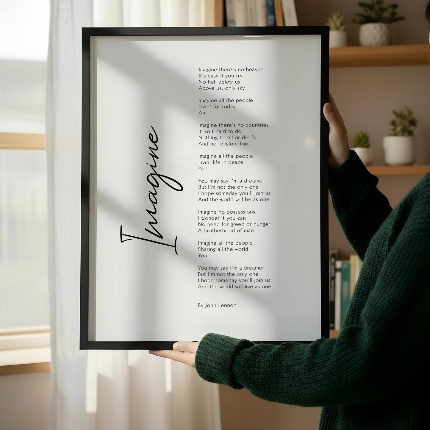 a framed poem titled "Imagine" leaning against a wall, with a wooden chair and a stack of books placed next to it on a wooden floor.