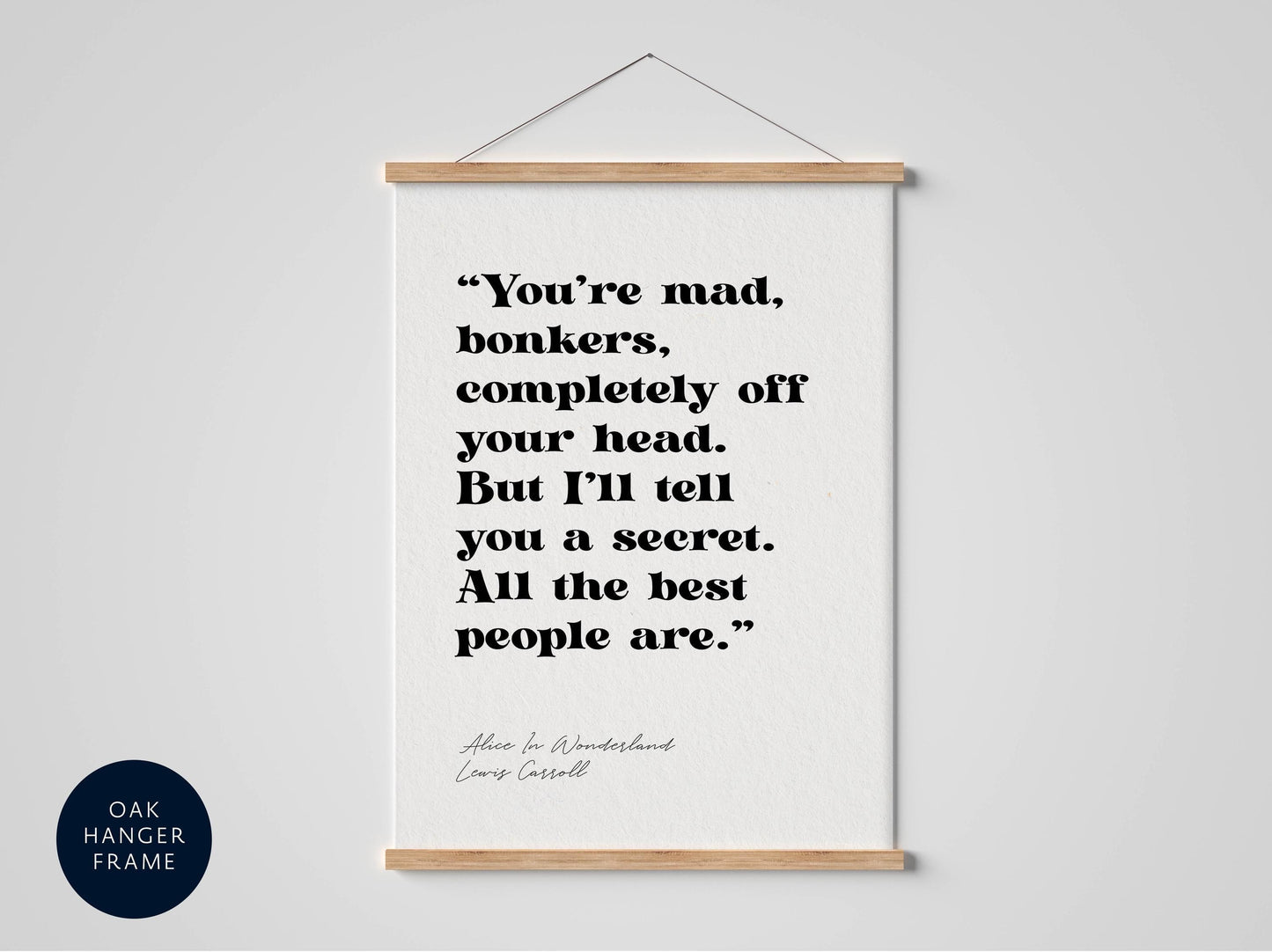 a framed quote from the book "Alice in Wonderland" by Lewis Carroll, which reads: "You're mad, bonkers, completely off your head. But I'll tell you a secret. All the best people are."