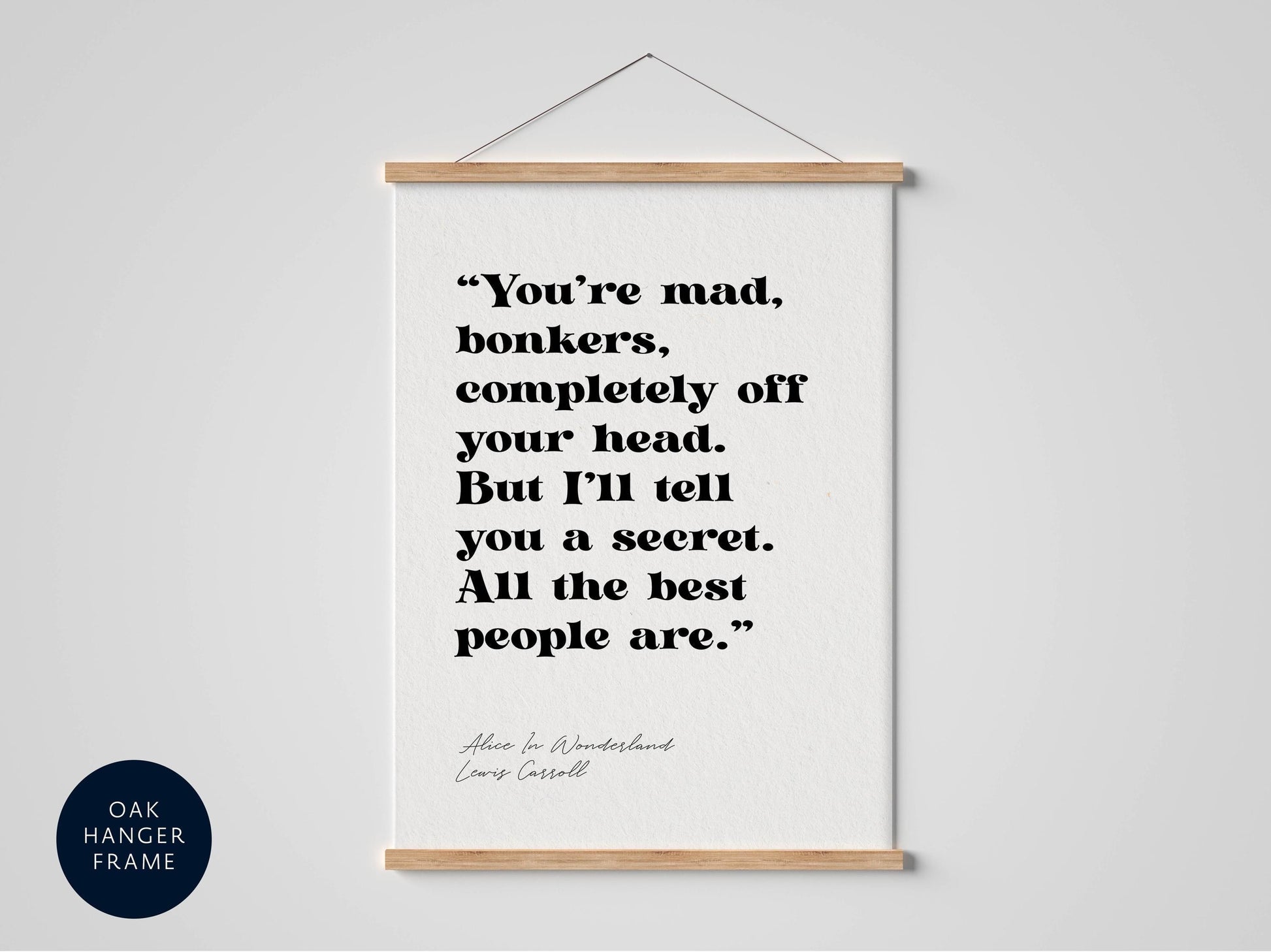 a framed quote from the book "Alice in Wonderland" by Lewis Carroll, which reads: "You're mad, bonkers, completely off your head. But I'll tell you a secret. All the best people are."