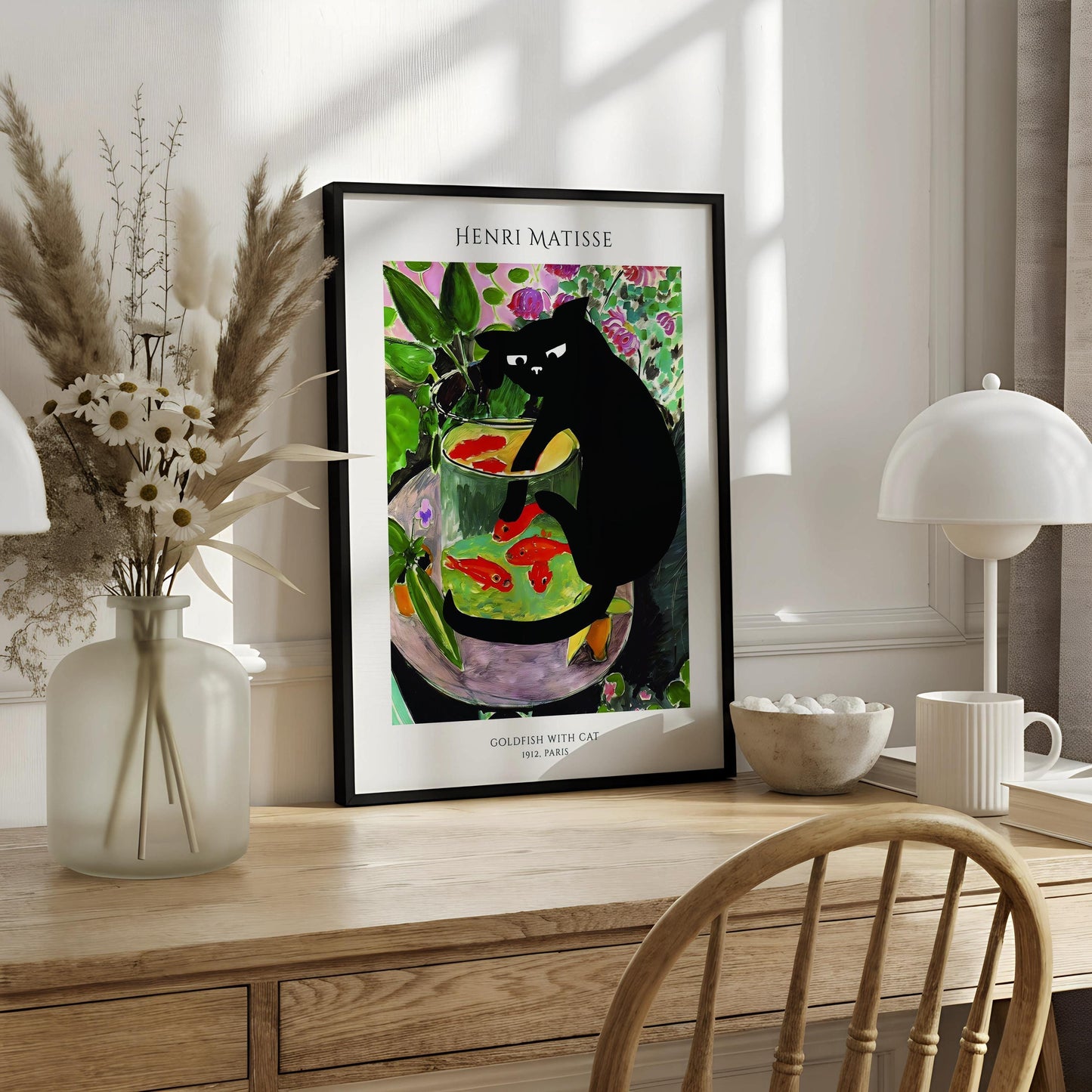 A framed painting of a black cat sitting in a glass bowl filled with goldfish, surrounded by colorful flowers and plants.
