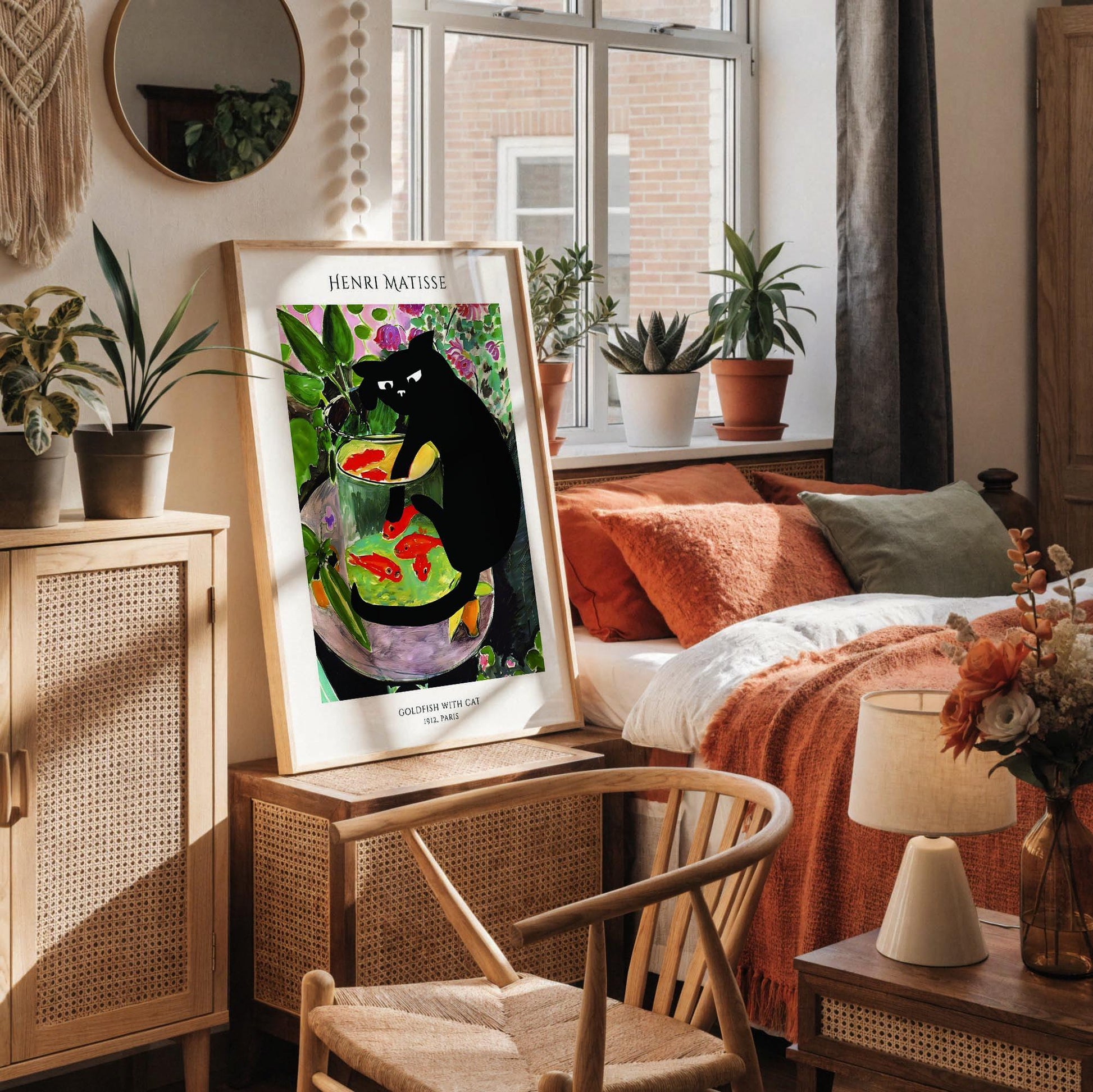 a framed painting of a black cat sitting in a fish bowl, surrounded by various objects such as a vase, a notebook, and a cup.