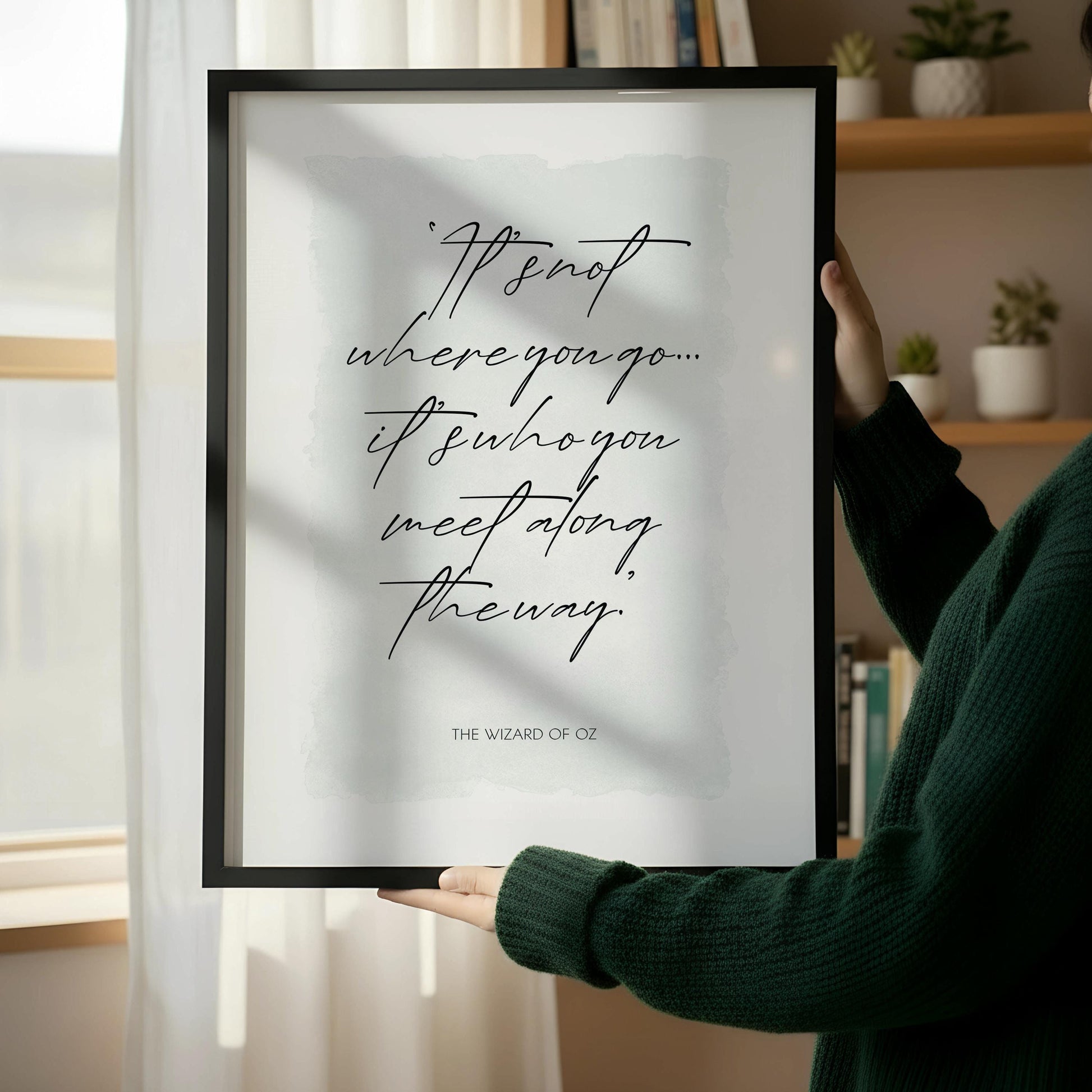 a framed quote on a wall next to a wooden chair with a stack of books on it.