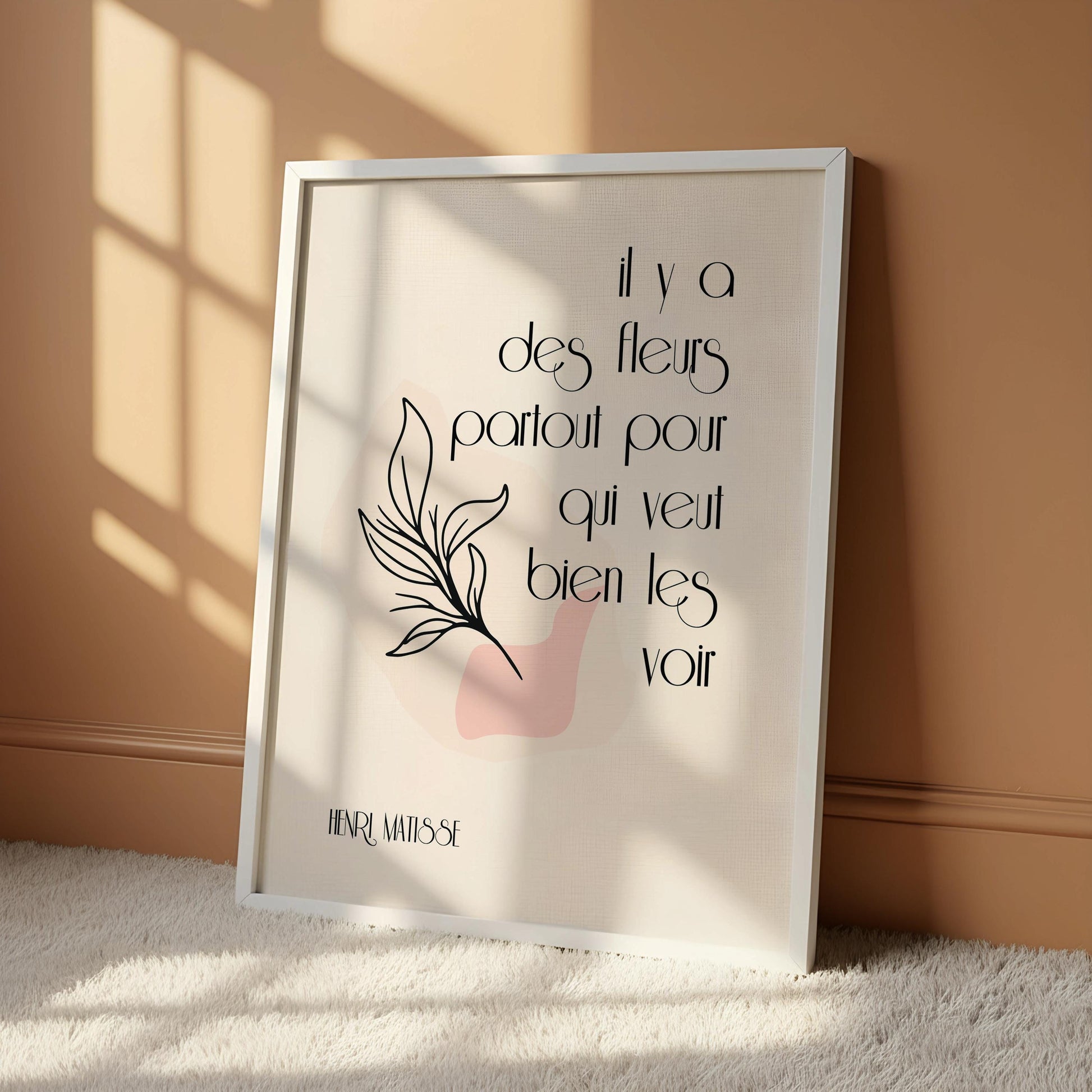 a framed poster with a quote on it, placed next to a wooden chair on a wooden floor.