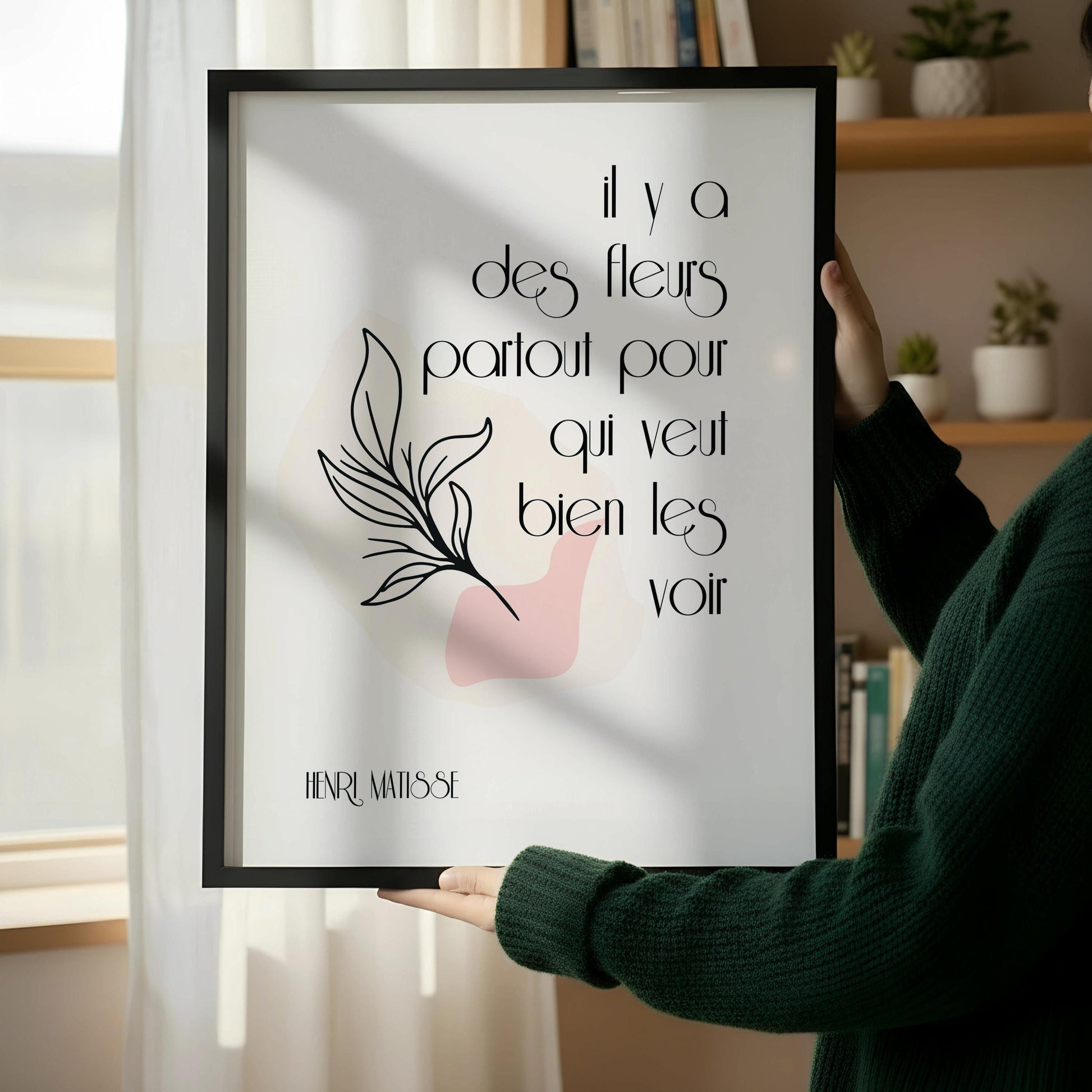 a framed poster with a quote in French, which reads "Il y a des fleurs partout pour qu'il vie tout bien les voirs" by Henri Matisse.