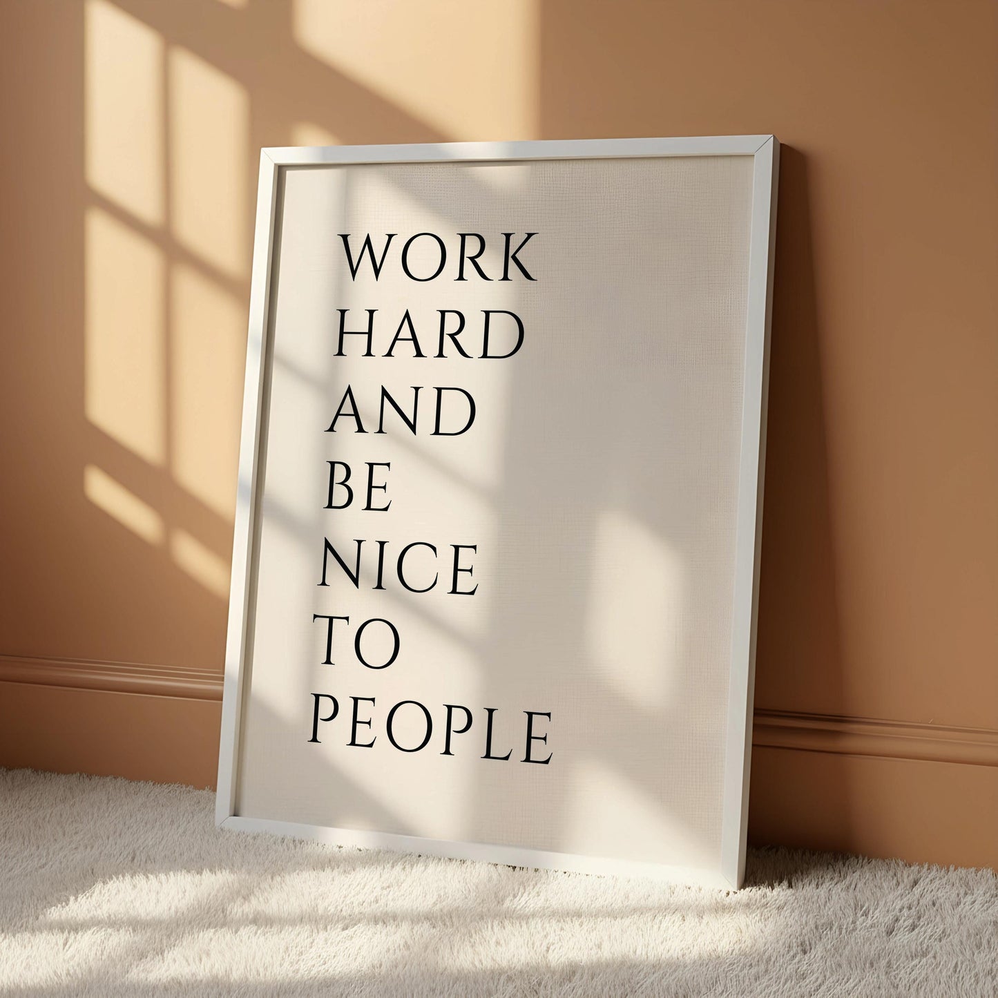 a white poster with black text that reads "WORK HARD AND BE NICE TO PEOPLE".