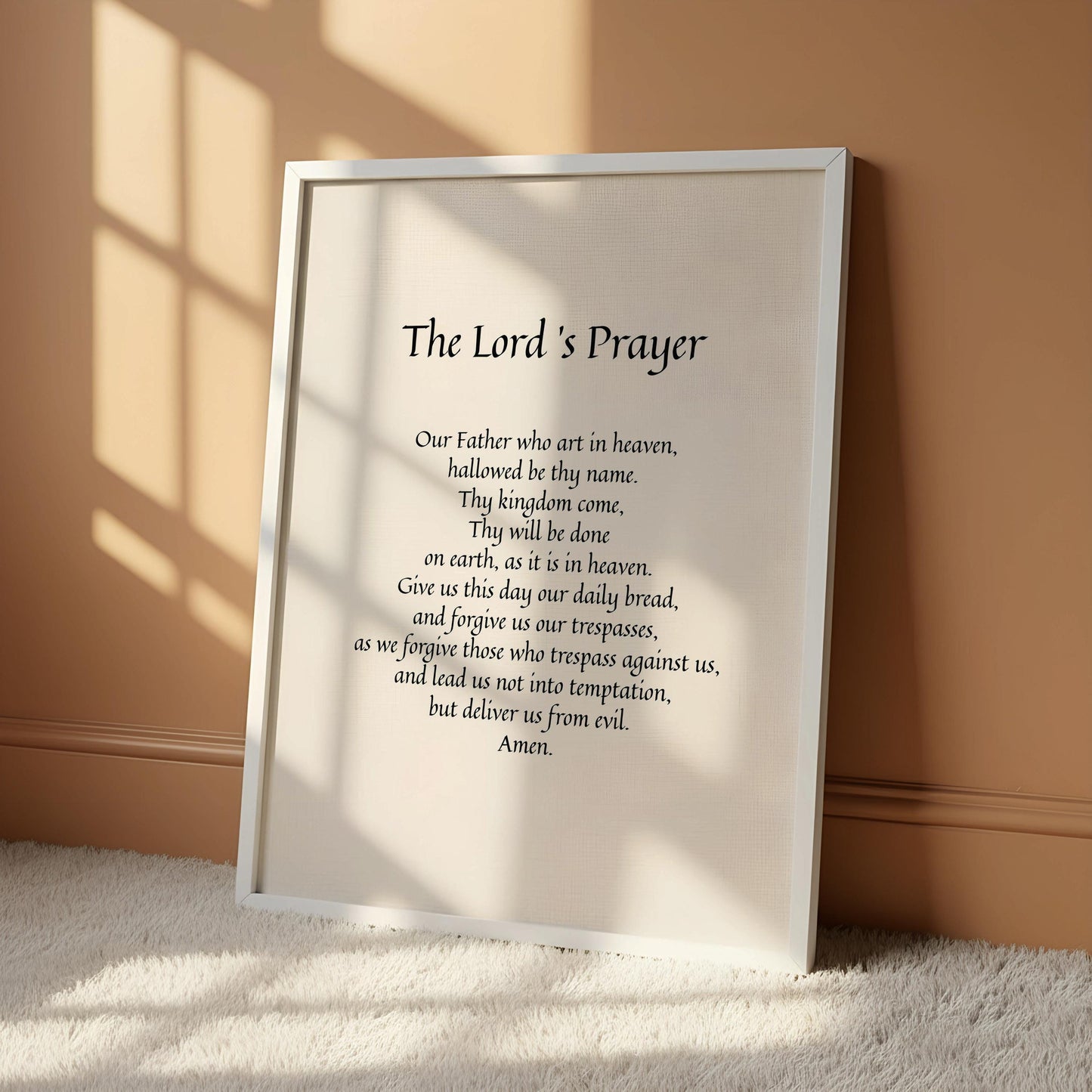 a framed prayer poster with a black and white design, hanging on a wall.