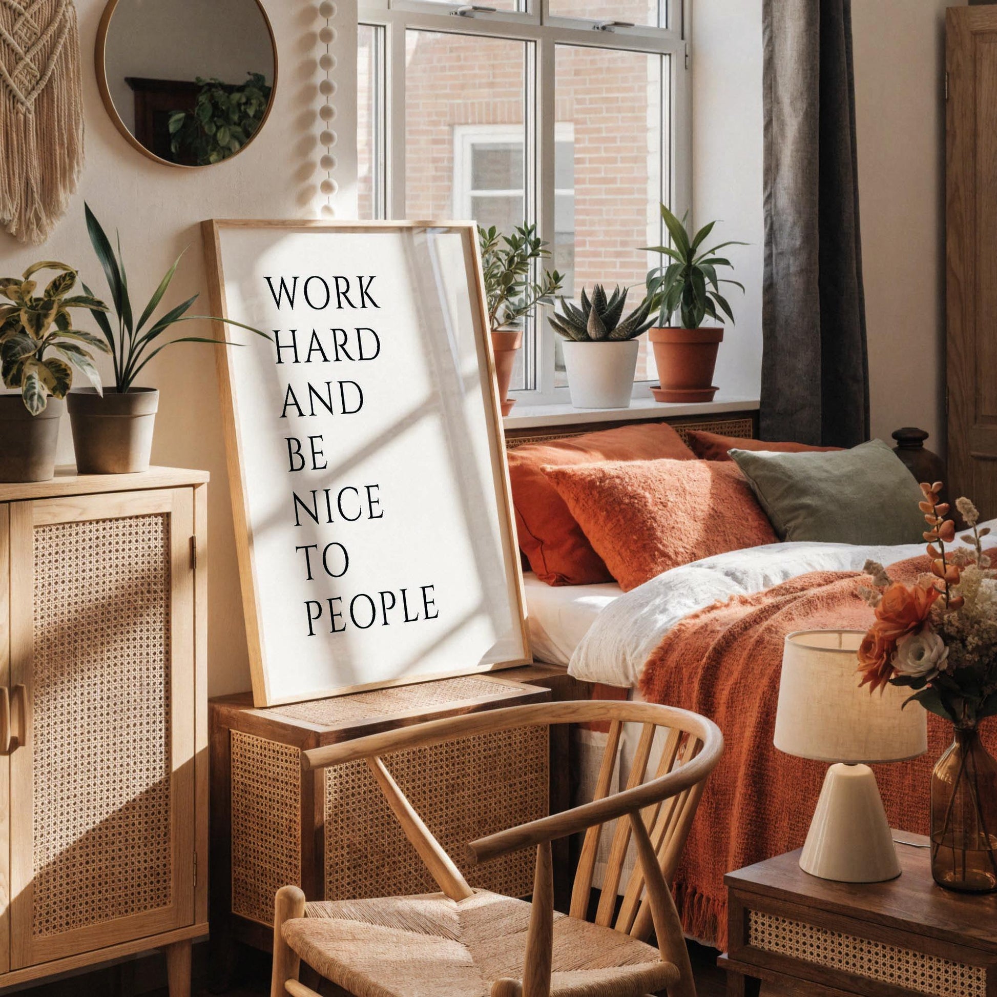 a white desk with a framed motivational quote, a notebook, a cup, and a vase with dried flowers.