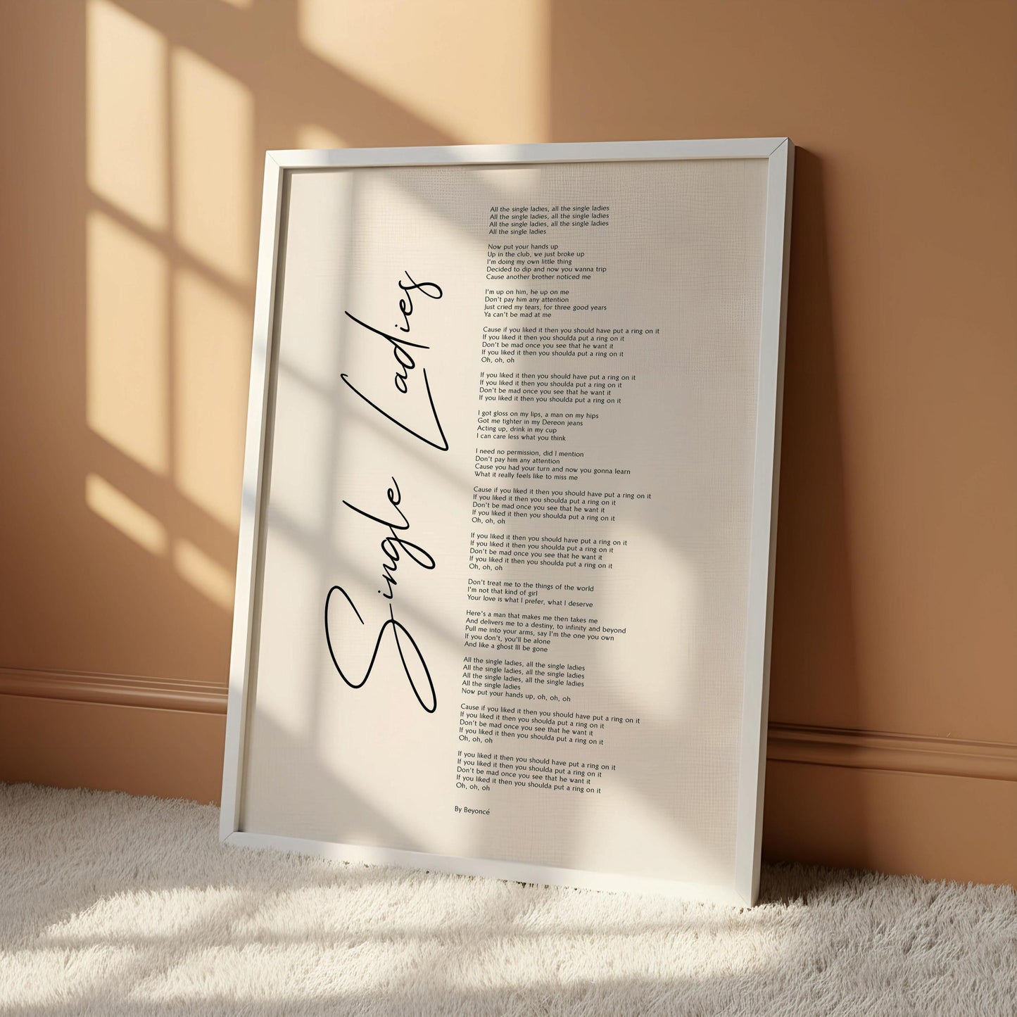 a poster with the title "Single Ladies" written in black cursive font, hanging on a wall.