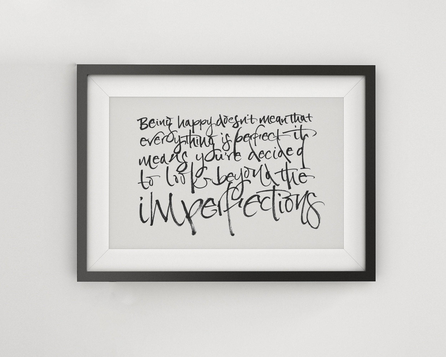 a framed quote with handwritten text that reads: "Being happy doesn't mean that everything is perfect. It means you've decided to be imperfect."
