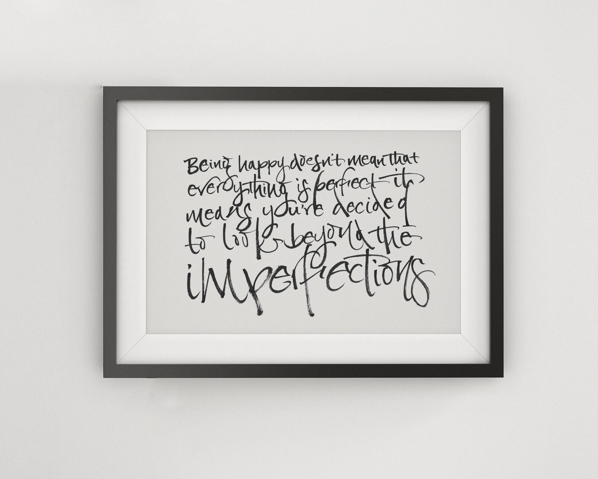 a framed quote with handwritten text that reads: "Being happy doesn't mean that everything is perfect. It means you've decided to be imperfect."
