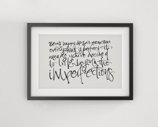a framed quote with handwritten text that reads: "Being happy doesn't mean that everything is perfect. It means you've decided to be imperfect."