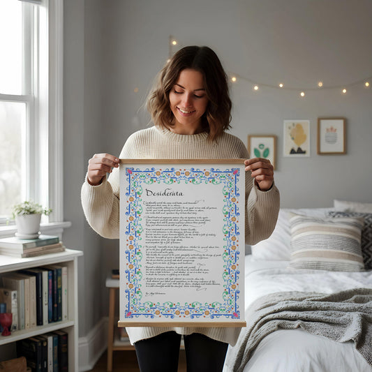 a framed poem titled "Dissiderta" leaning against a white wall, with a wooden chair and a stack of books placed next to it on a wooden floor.