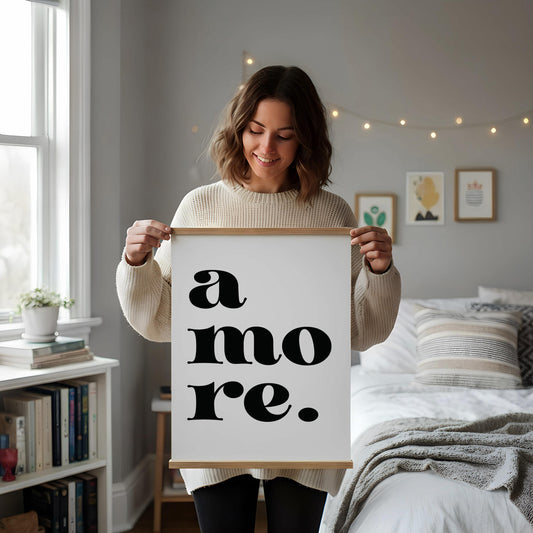 a white desk with a framed poster displaying the text "a more." The desk also has various items such as a cup, a notebook, and a vase with dried flowers.