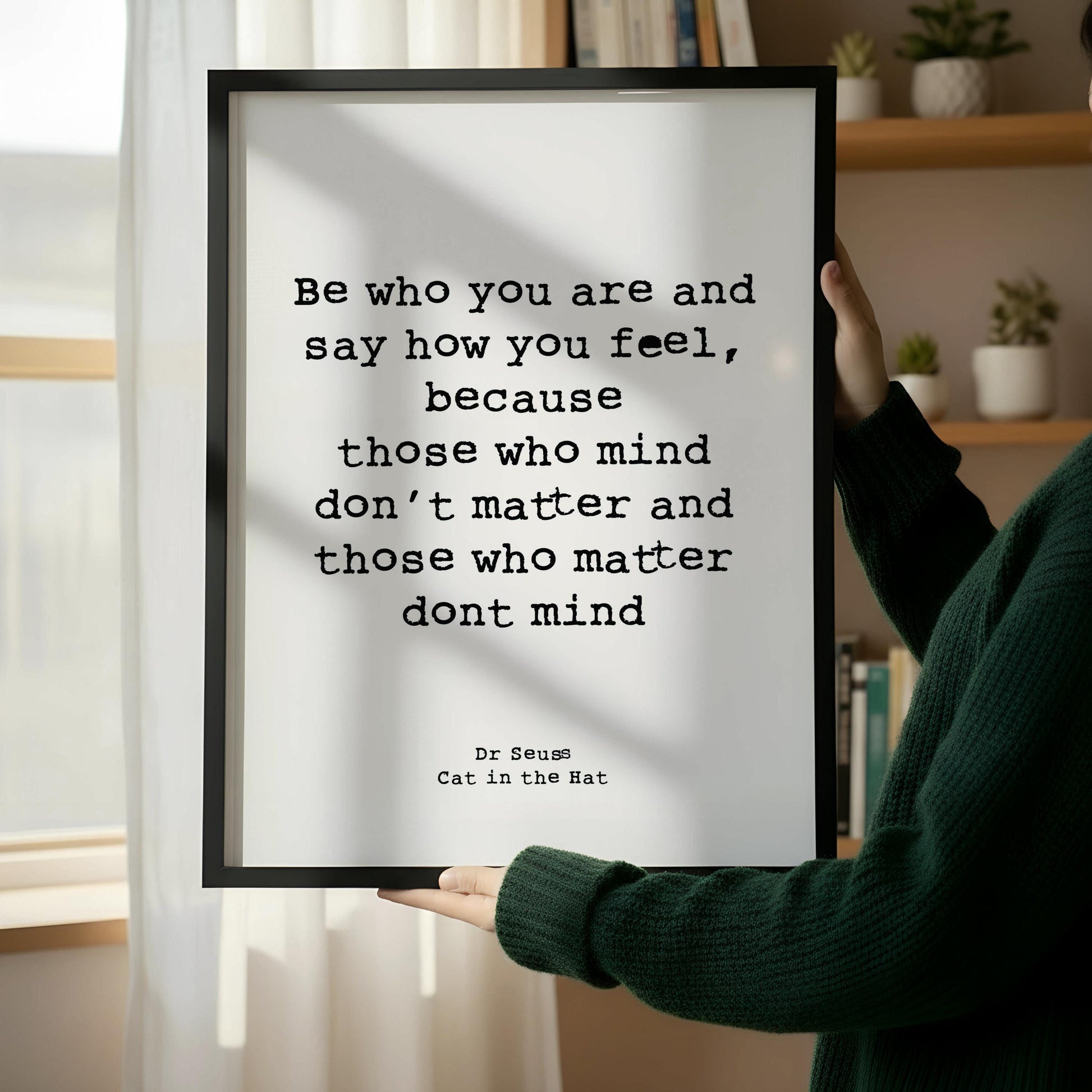 A framed quote about self-esteem and self-worth is leaning against a wooden chair on a wooden floor.