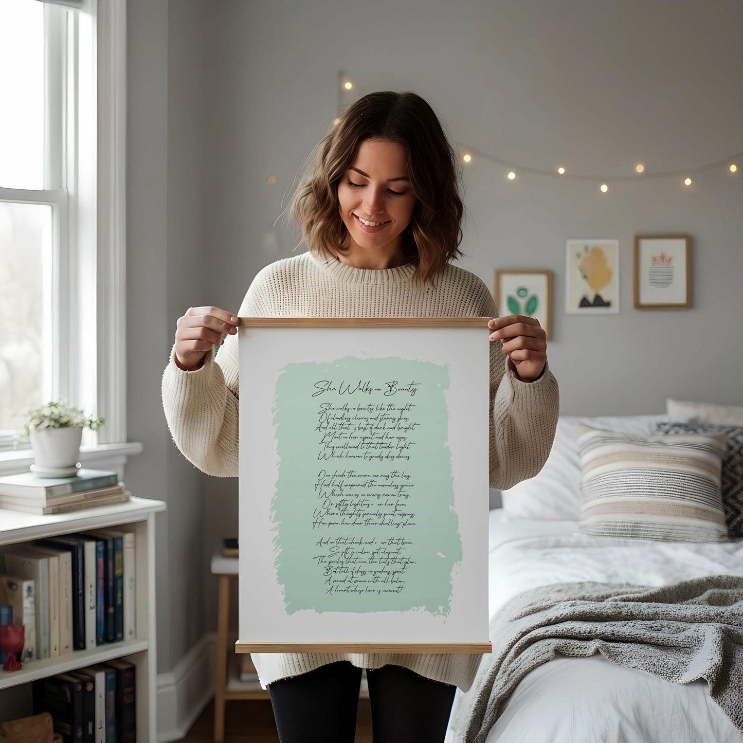 a framed print of a poem on a white desk, accompanied by a notebook, a cup, and a vase with dried flowers.