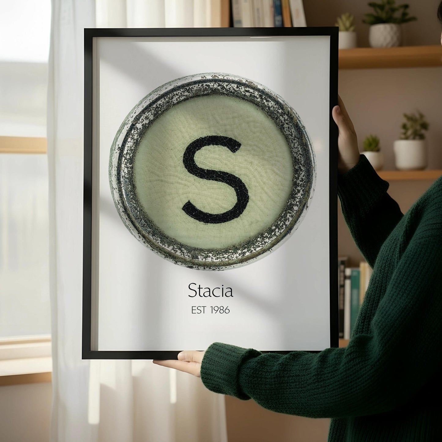 a framed poster with a large letter 'S' on it, placed on a wooden floor next to a wooden chair.