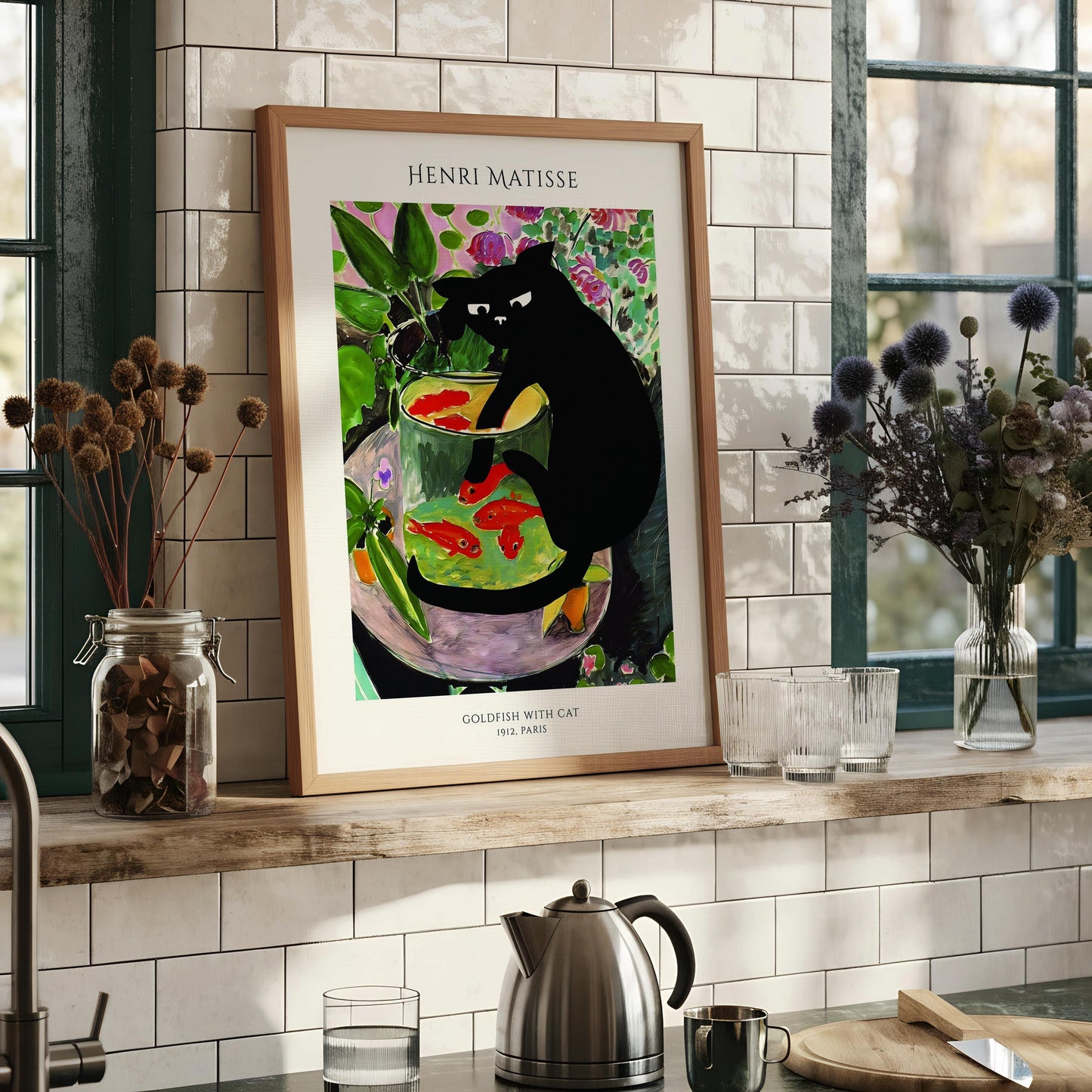 The image is a framed print of the famous painting "Goldfish with Cat" by Henri Matisse, which depicts a black cat sitting in a glass bowl filled with fish.
