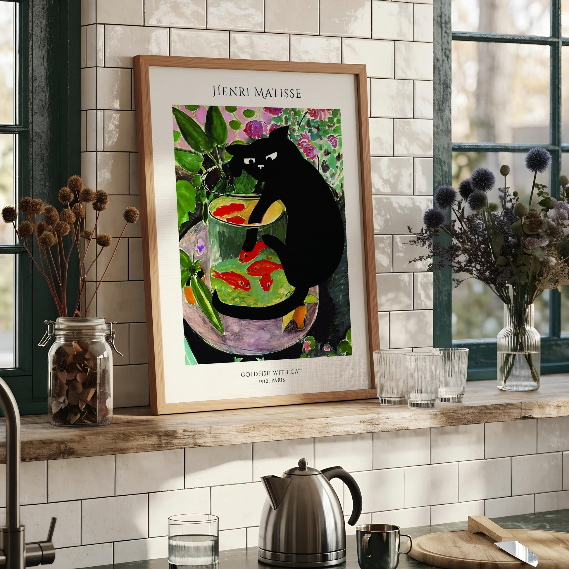 The image is a framed print of the famous painting "Goldfish with Cat" by Henri Matisse, which depicts a black cat sitting in a glass bowl filled with fish.