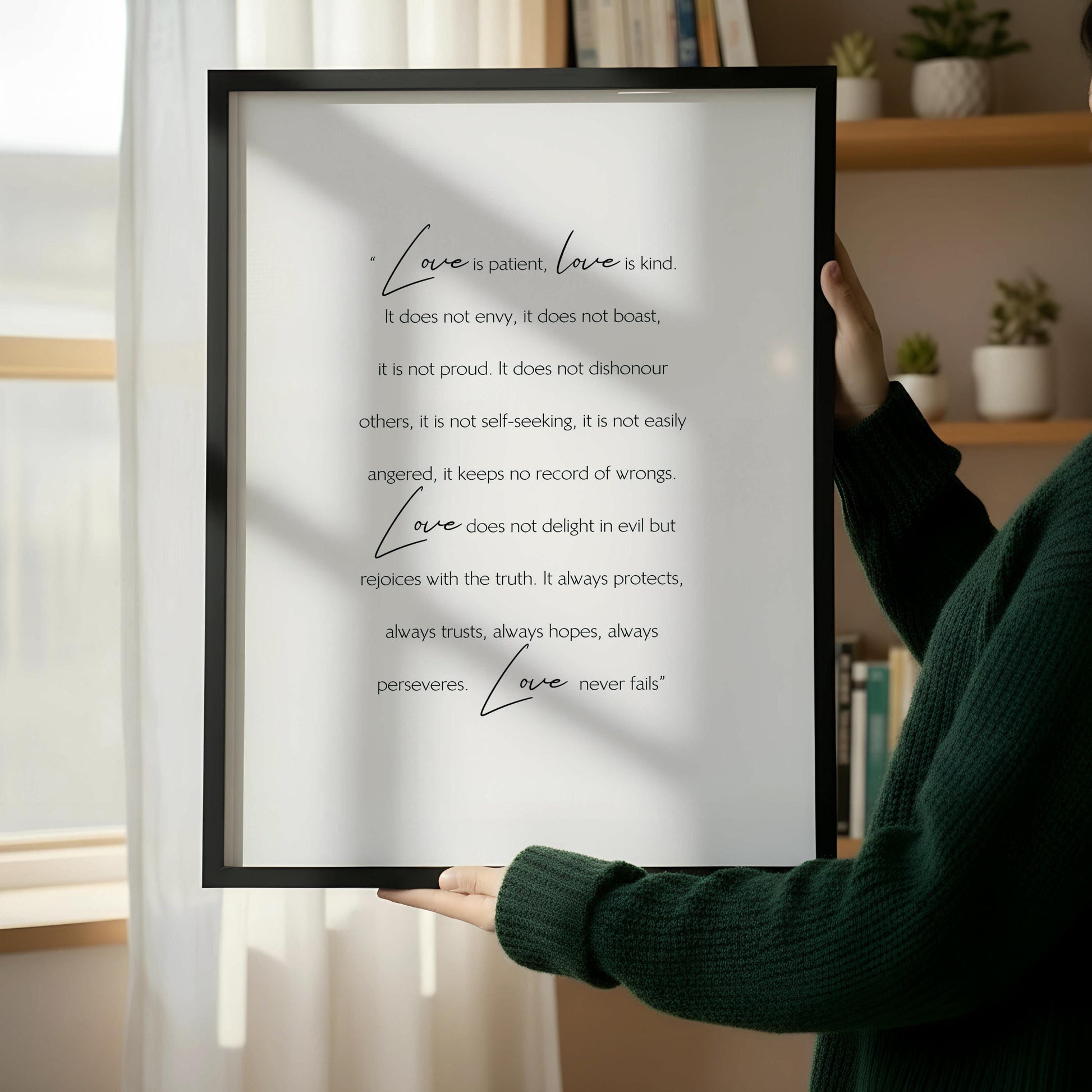 a wooden chair with a framed quote about love placed next to it on a white wall.