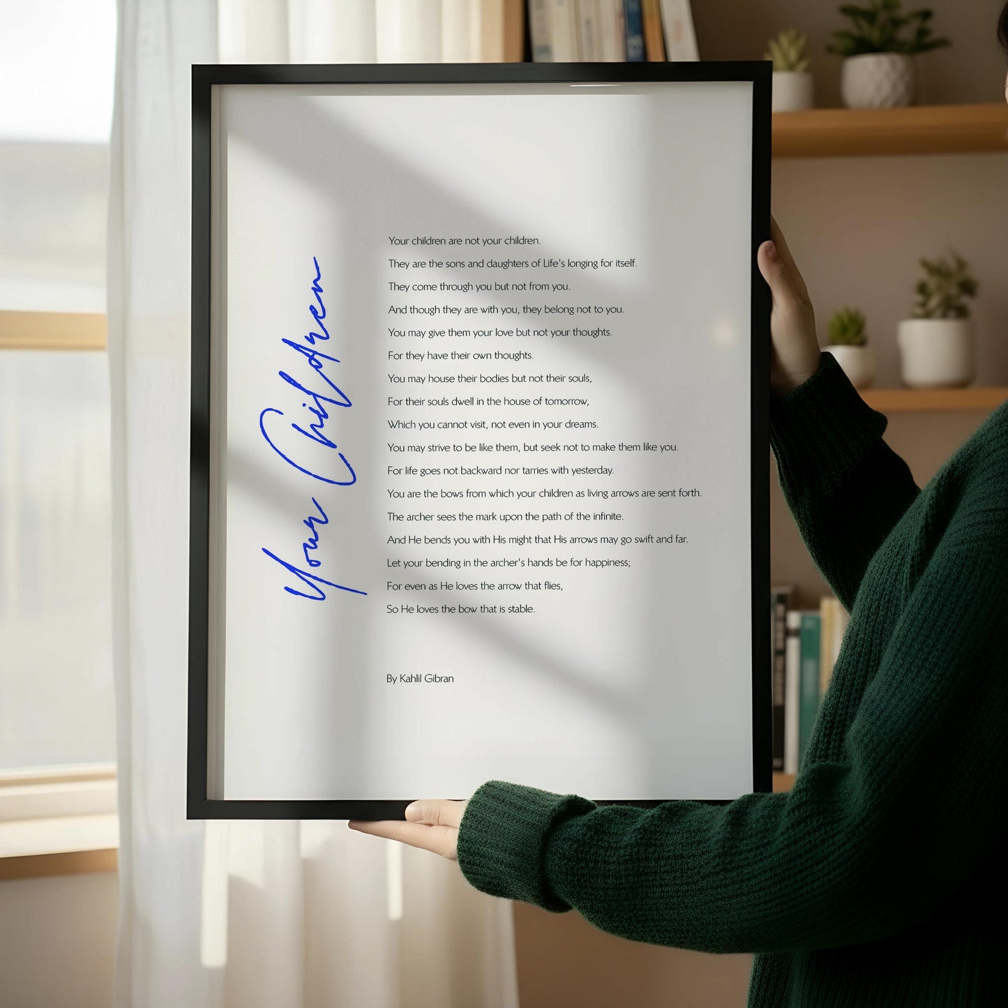 a framed poem titled "Your Children" by Rabbi Glaser, placed on a wooden floor next to a wooden chair.