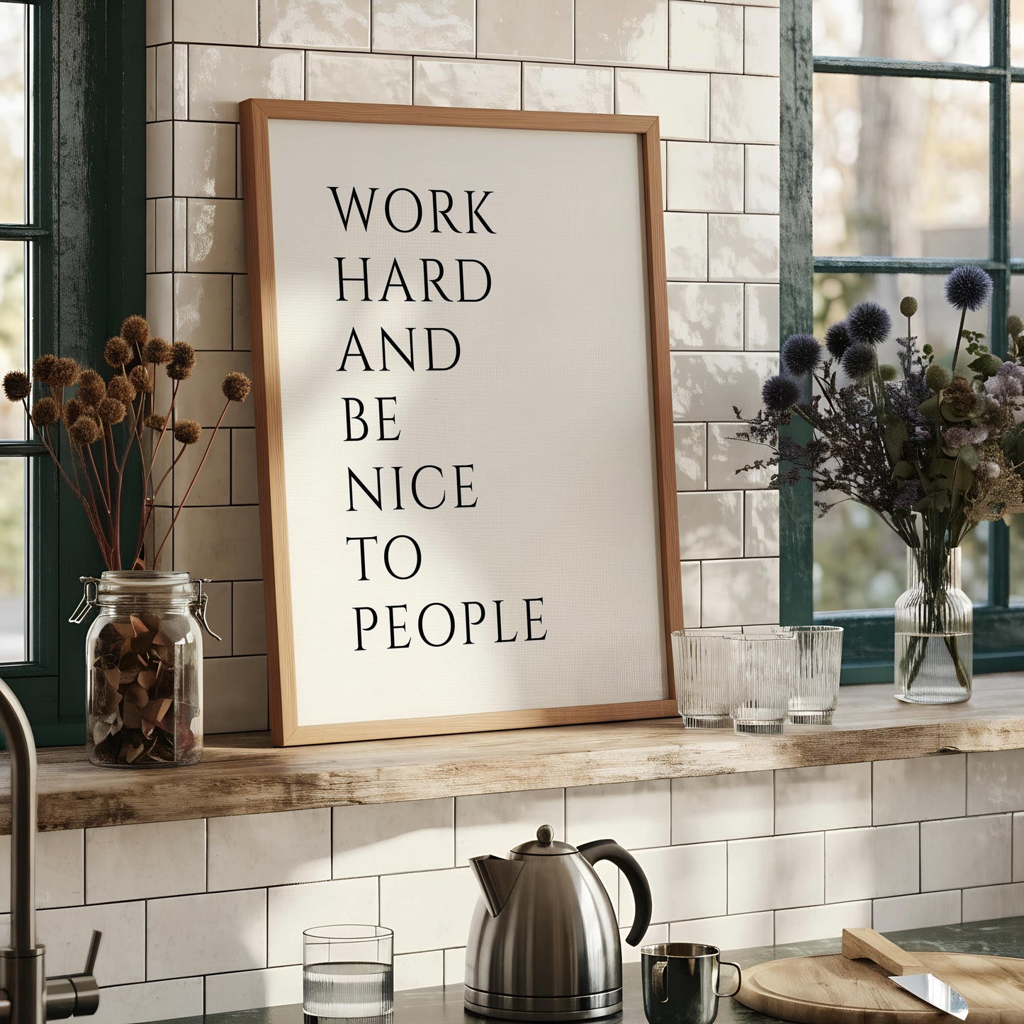 a framed poster with the text "WORK HARD AND BE NICE TO PEOPLE" displayed on it.