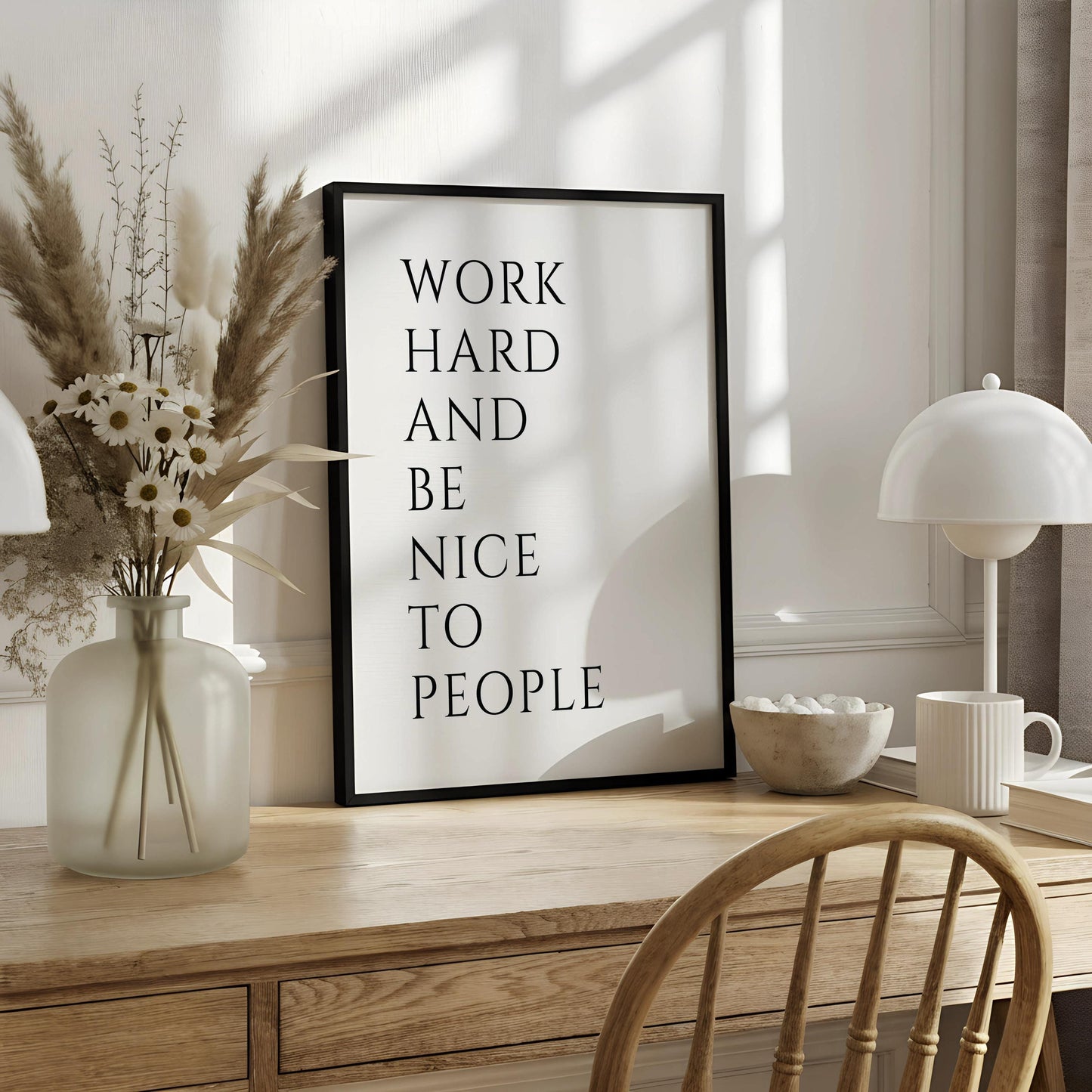 a motivational quote poster hanging on a wall, which reads "WORK HARD AND BE NICE TO PEOPLE".