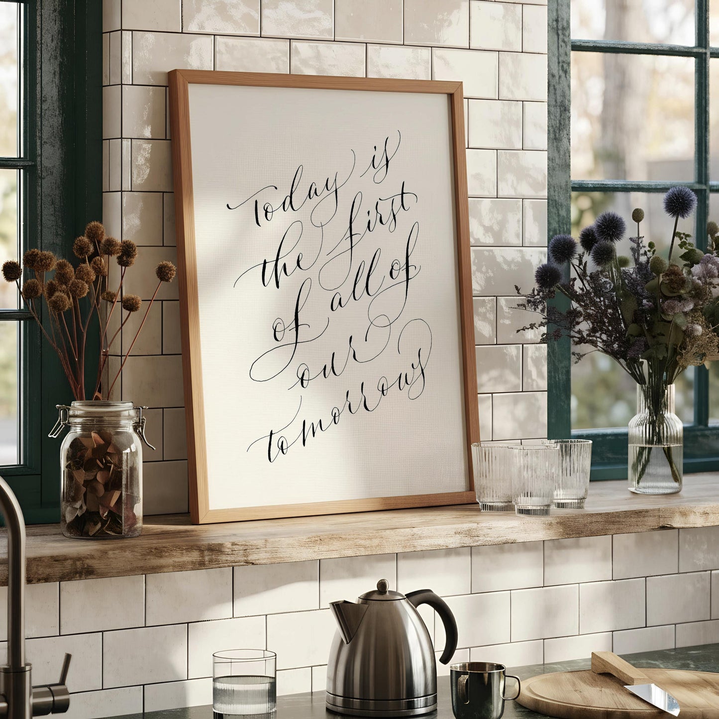 a framed print with a quote in black cursive text that reads "Today is the first of all of our tomorrow".