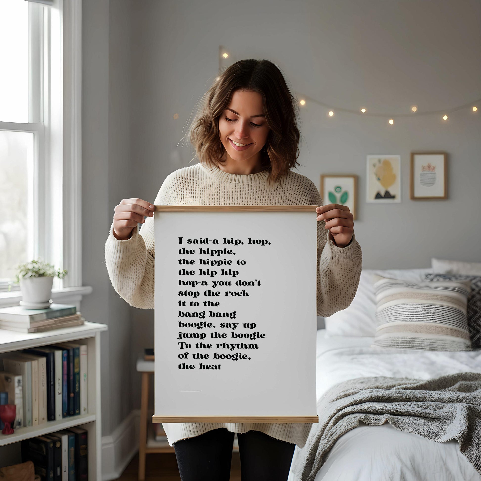 a framed quote on a white wall, accompanied by a white desk with various items such as a coffee cup, a notebook, and a vase with dried flowers.